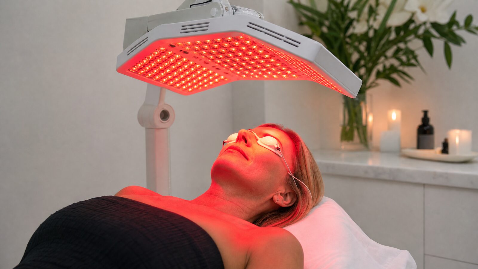 A woman receiving red light therapy for skin rejuvenation in a modern Irish clinic